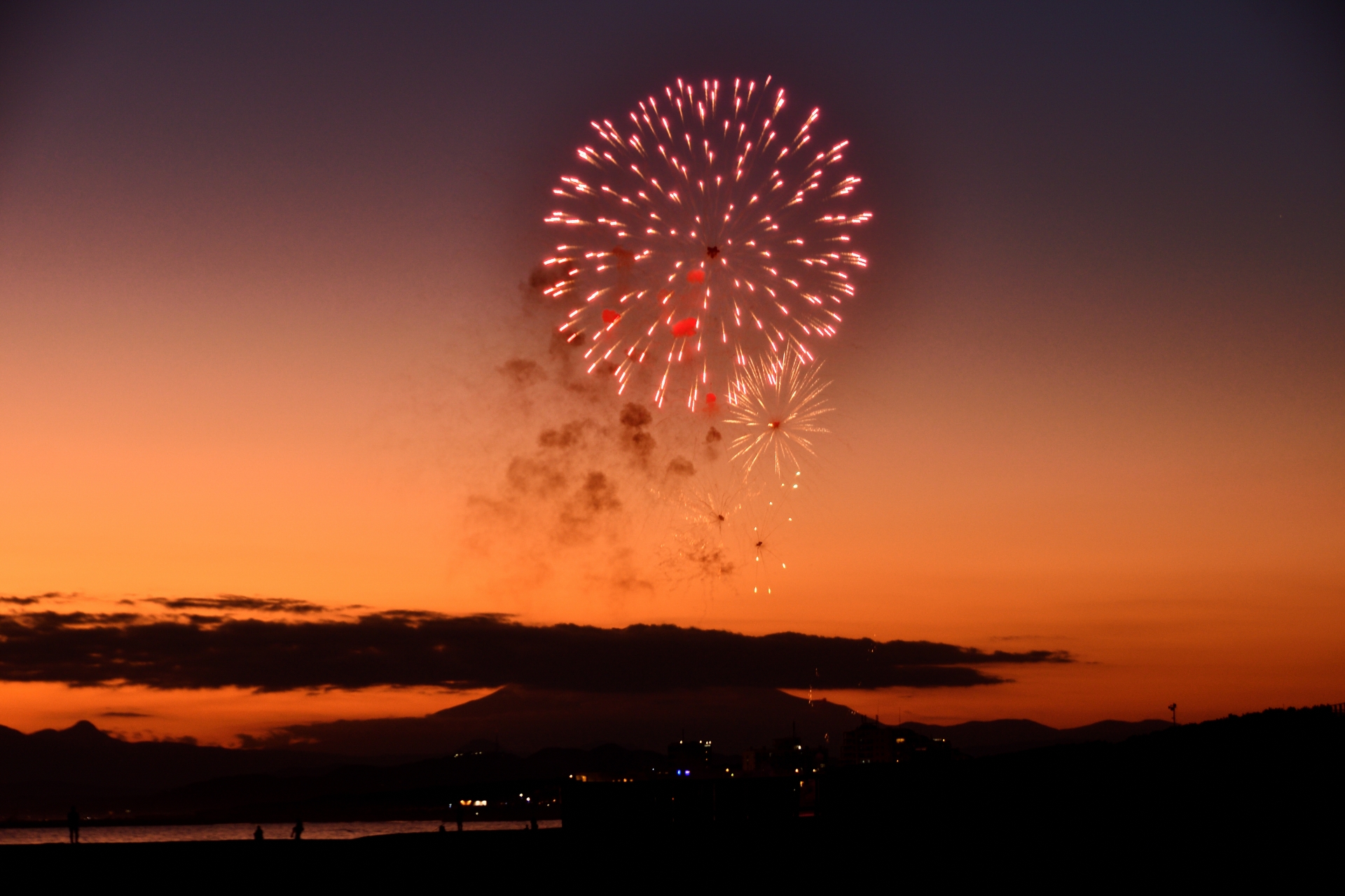 alt="サザンビーチ茅ヶ崎で打ち上がる夕暮れの花火"